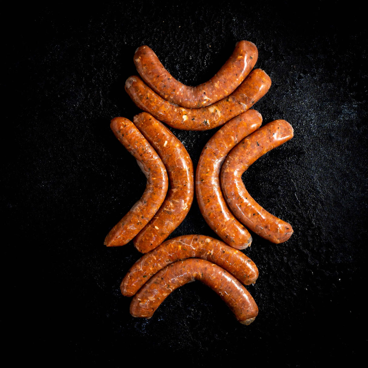 a group of hot dogs sitting on a black surface