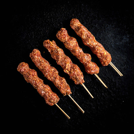 a group of hot dogs cooking on a grill
