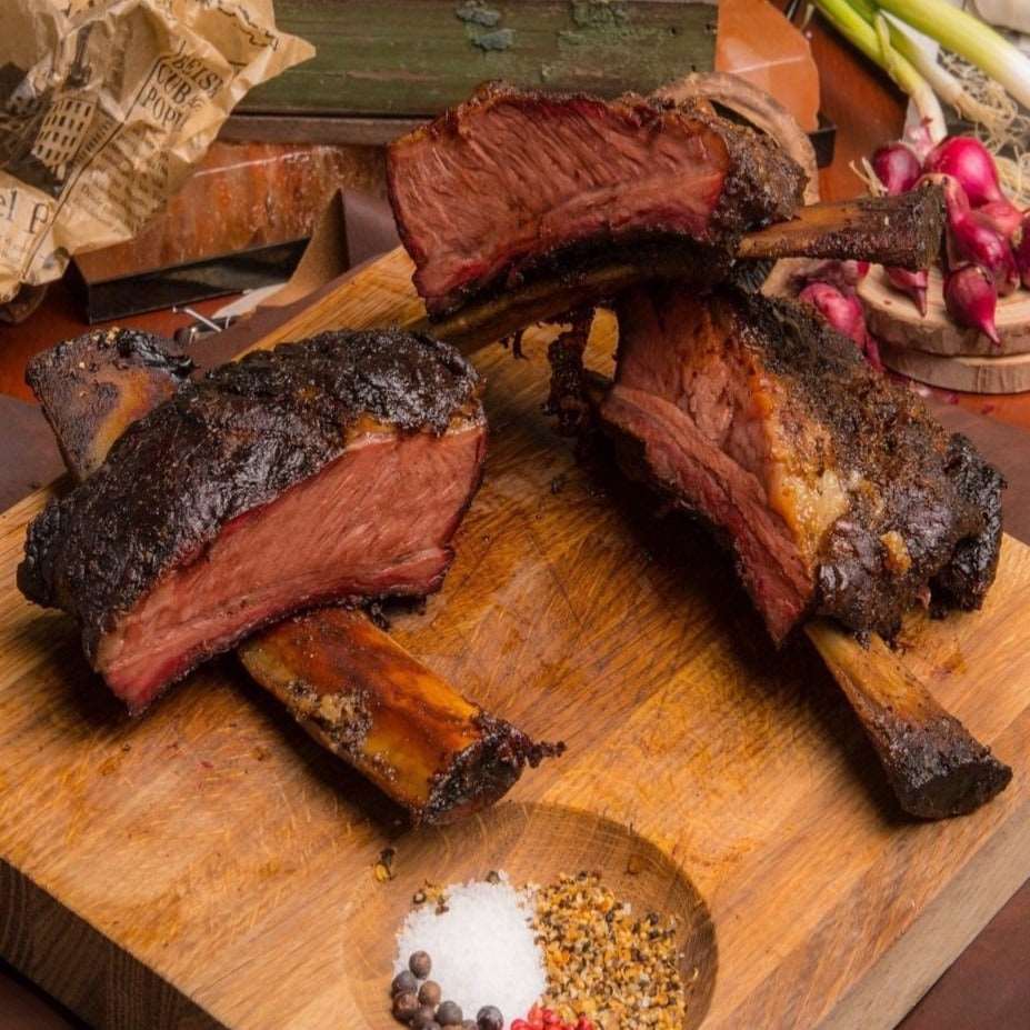 a wooden table topped with meat and vegetables