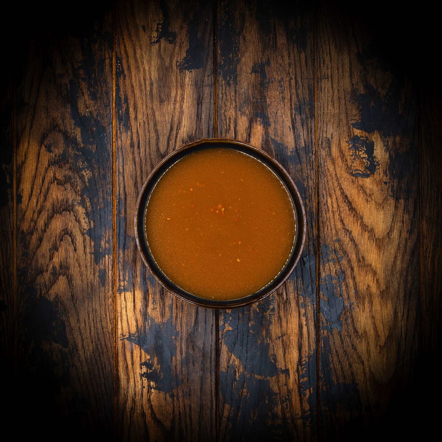 a bowl of food sitting on top of a wooden table