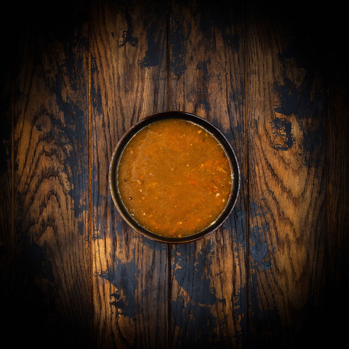 a close up of a bowl of food on a wooden table