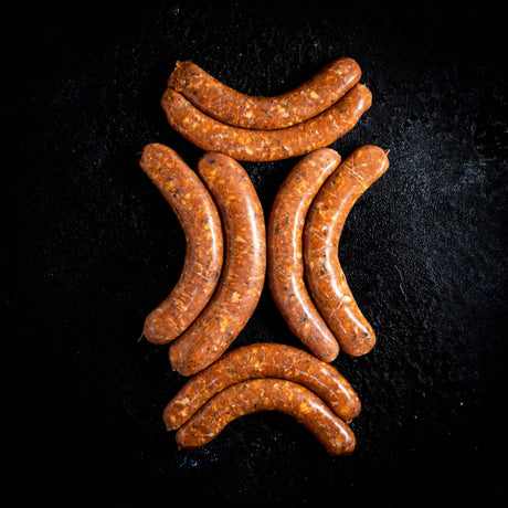 a bunch of hot dogs sitting on a black surface