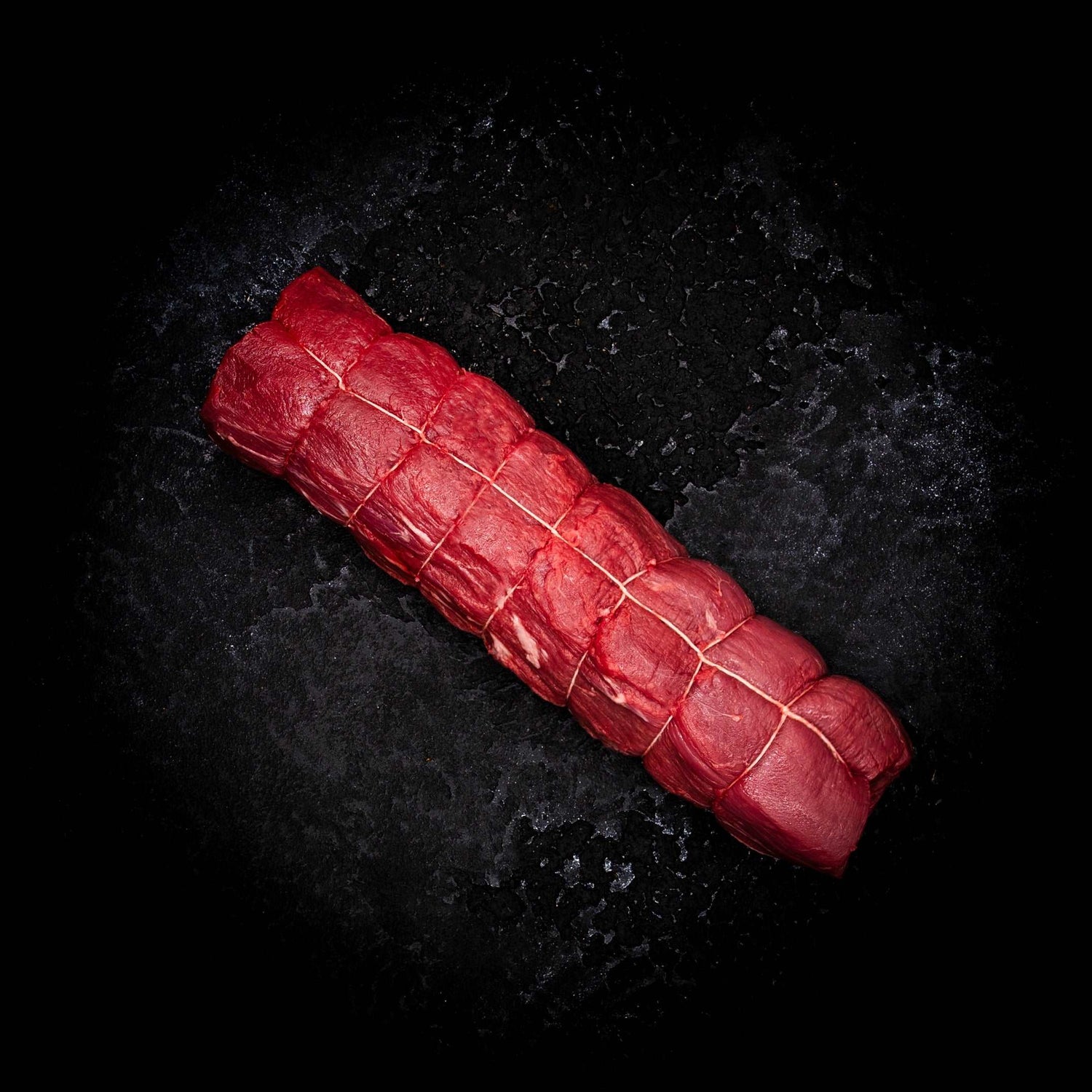 a red carrot is laying on a black background