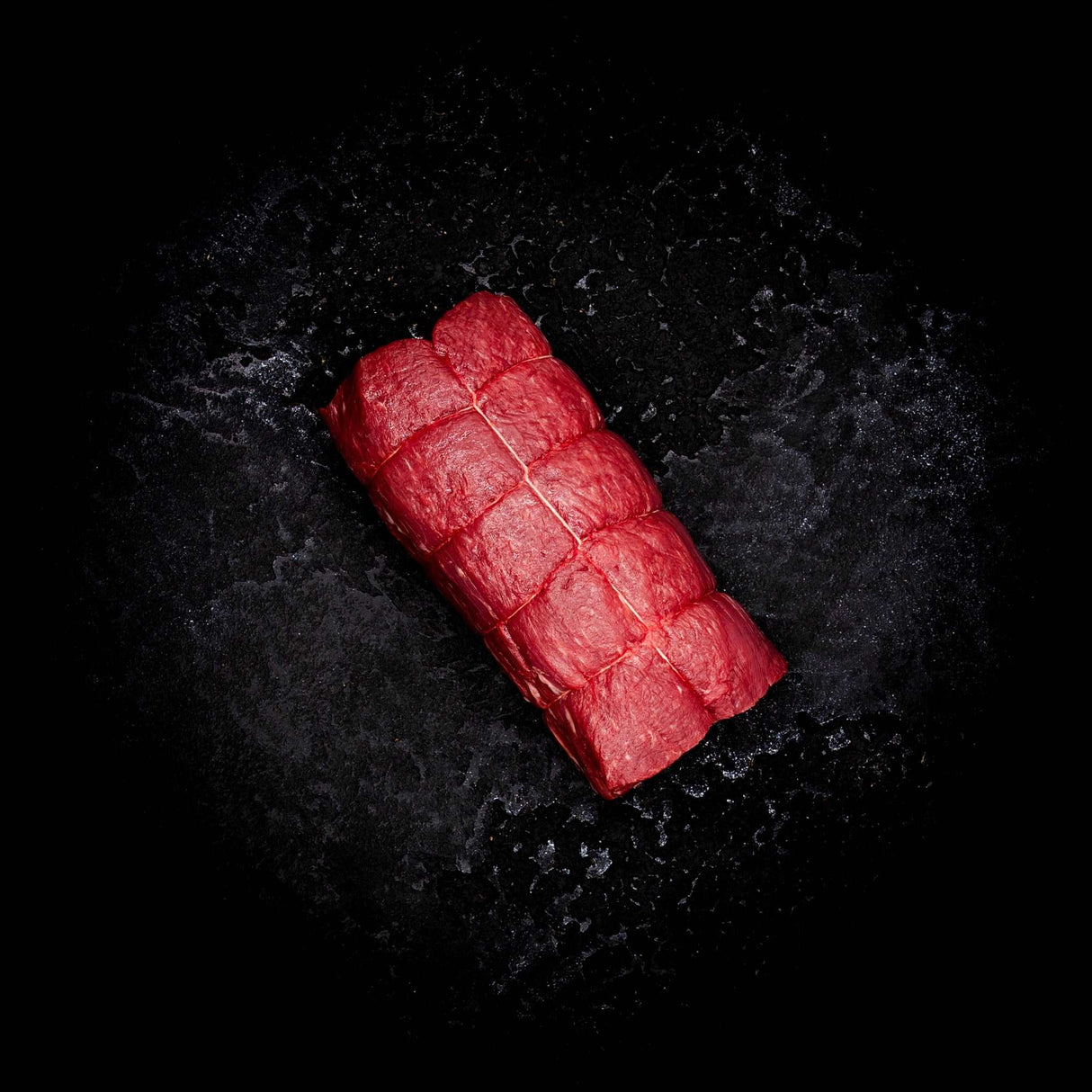 a red carrot laying on a black surface