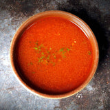 a bowl of orange soup sitting on top of a counter 