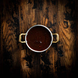 a cup of coffee sitting on top of a wooden table 