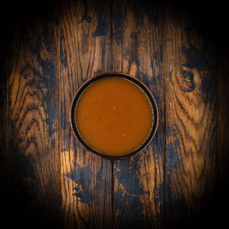 a bowl of food sitting on top of a wooden table 