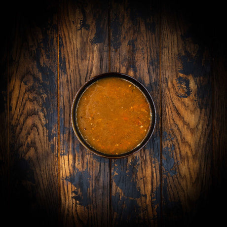 a close up of a bowl of food on a wooden table 