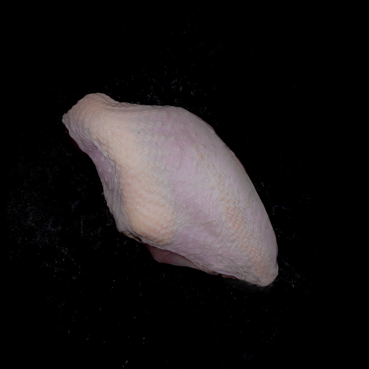 a close up of a white apple in a black background 