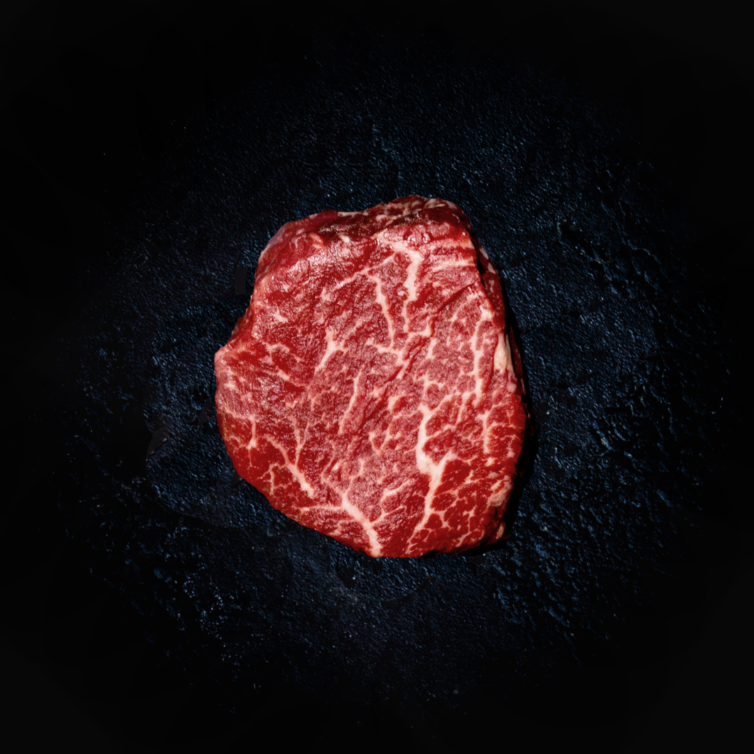 A single piece of Wagyu Tenderloin steak on a dark, textured background.
