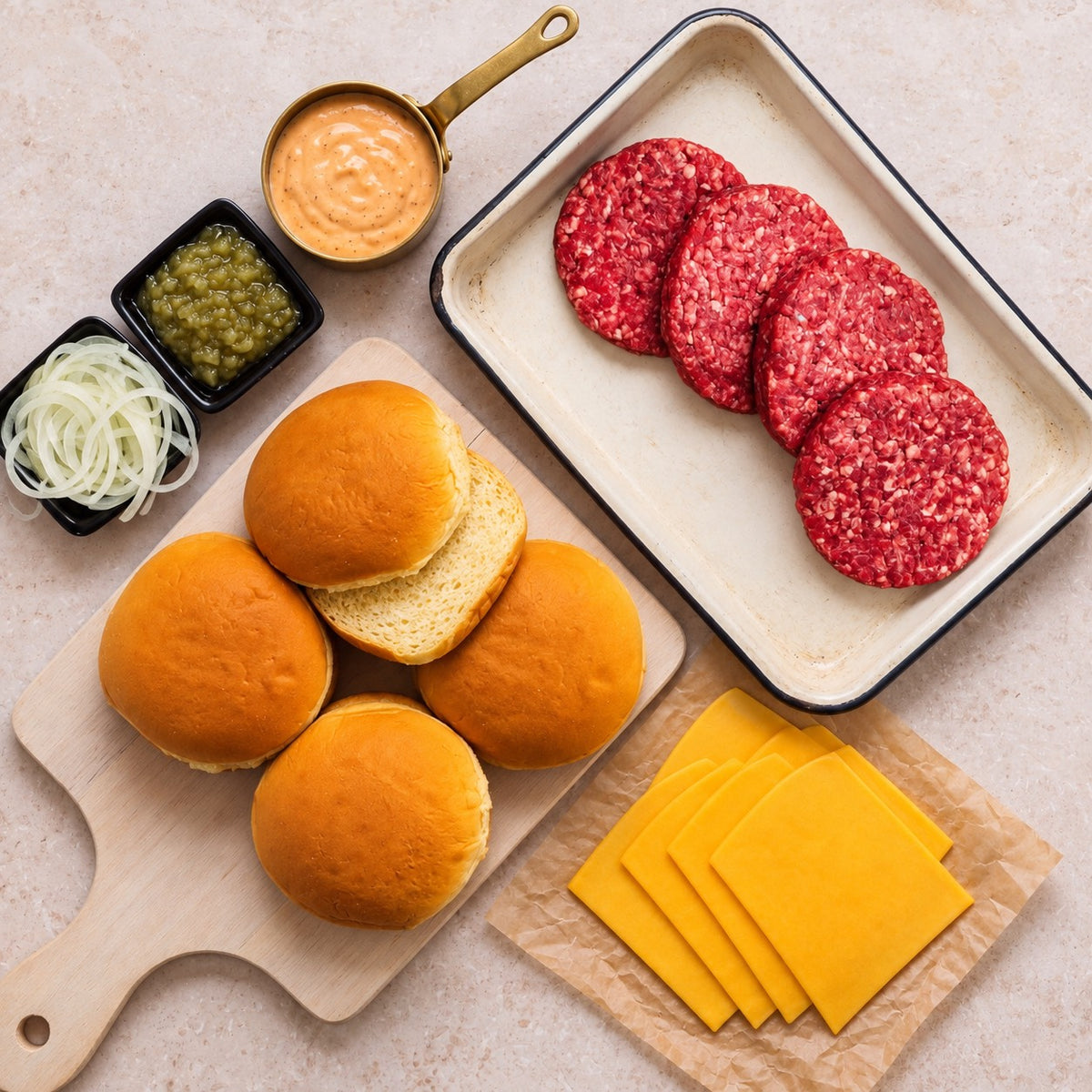 Grass-fed Burger Box with four raw beef patties, potato buns, cheddar slices, burger sauce, onions and relish.