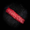 a red carrot is laying on a black background 