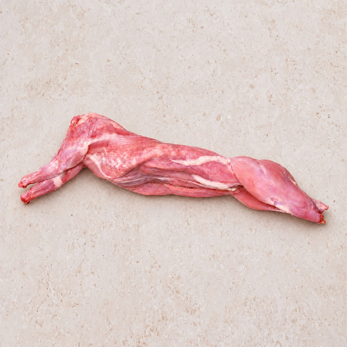 Whole raw rabbit on a light limestone surface.